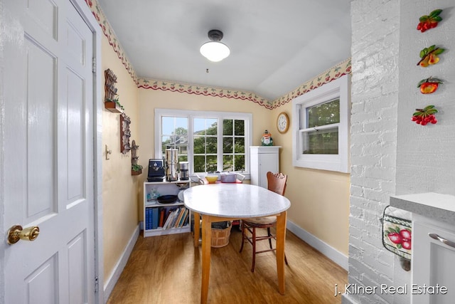 7115 Bronson St SE, Ada, MI 49301 - dining area with light wood-type flooring and vaulted ceiling