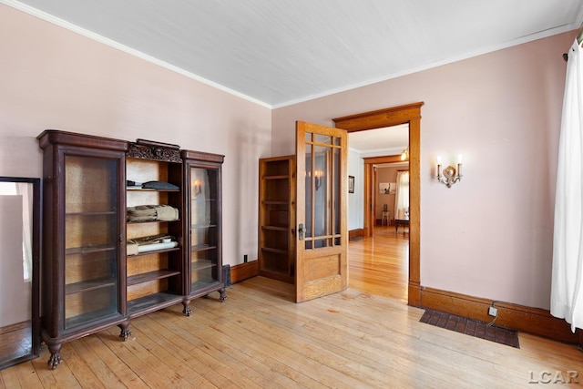 203 S Main St, Onsted, MI 49265 - spare room featuring light wood-style flooring and ornamental molding