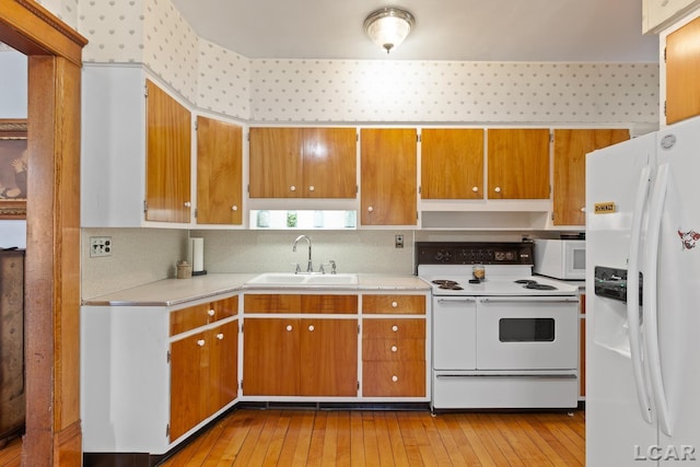 203 S Main St, Onsted, MI 49265 - kitchen with white appliances, light countertops, light wood-style flooring, and brown cabinetry