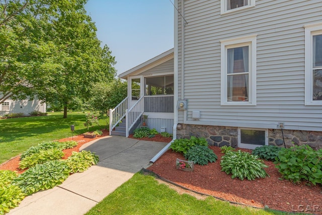 203 S Main St, Onsted, MI 49265 - doorway to property with a lawn and stone siding