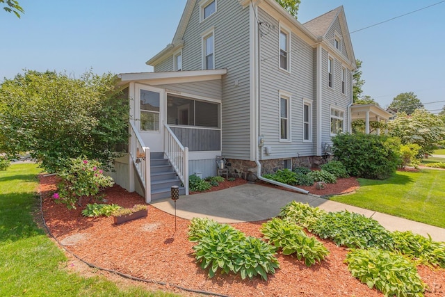 203 S Main St, Onsted, MI 49265 - view of front of property with a sunroom, a front yard, and a patio area