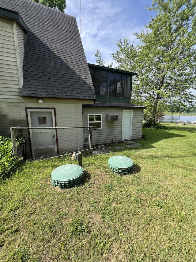 7428 Ansley Ln, Hillsdale, MI 49242 - rear view of property with roof with shingles, a yard, brick siding, and a sunroom