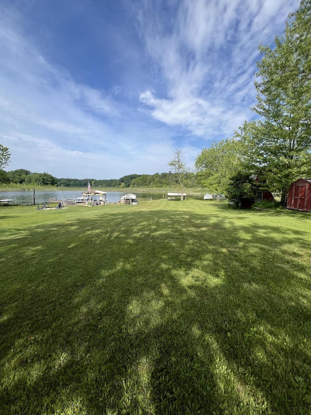 7428 Ansley Ln, Hillsdale, MI 49242 - view of green lawn featuring a storage unit, a water view, and a boat dock