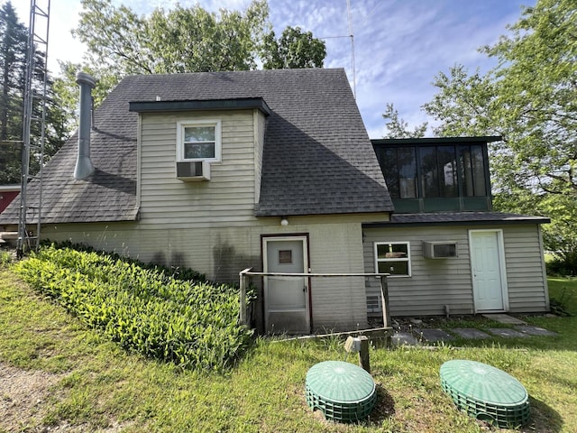 7428 Ansley Ln, Hillsdale, MI 49242 - rear view of house featuring roof with shingles, brick siding, a sunroom, a yard, and a wall mounted AC