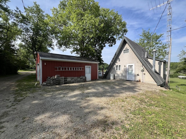 7428 Ansley Ln, Hillsdale, MI 49242 - view of side of home featuring an outdoor structure, a pole building, and a yard