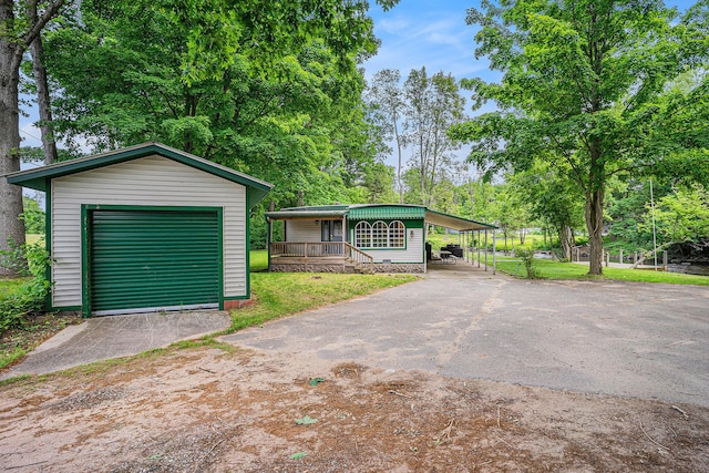 8933 E M 20, Hesperia, MI 49421 - view of front of home featuring asphalt driveway, an outbuilding, a garage, and a front lawn