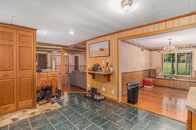 8933 E M 20, Hesperia, MI 49421 - dining space with wooden walls, a chandelier, wainscoting, and ornamental molding