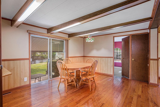 8933 E M 20, Hesperia, MI 49421 - dining space with light wood-style floors, wainscoting, beamed ceiling, plenty of natural light, and wooden walls