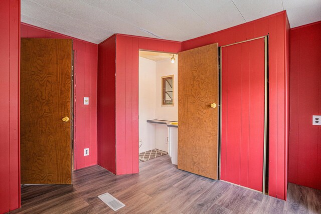 8933 E M 20, Hesperia, MI 49421 - unfurnished bedroom featuring wood finished floors, a closet, and wood walls