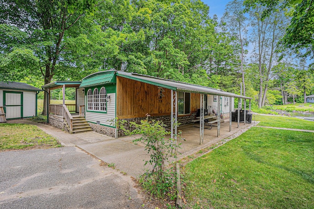 8933 E M 20, Hesperia, MI 49421 - view of front of home with a front lawn, a storage shed, covered porch, crawl space, and a metal roof