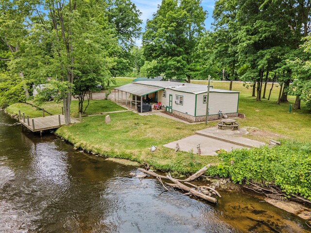 8933 E M 20, Hesperia, MI 49421 - rear view of house with a fire pit, a lawn, and view of scattered trees