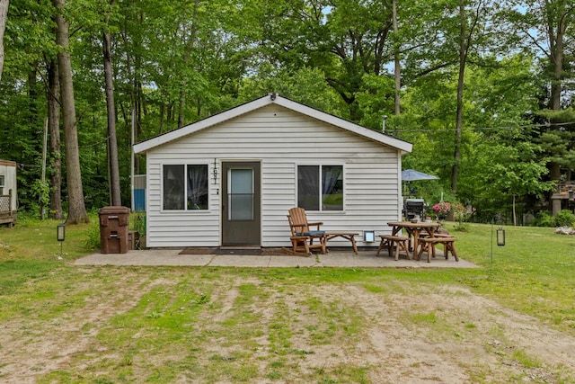 11681 Heron Dr, Lakeview, MI 48850 - rear view of house with a patio, a yard, and view of wooded area