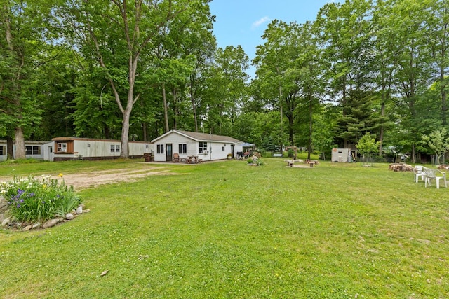 11681 Heron Dr, Lakeview, MI 48850 - view of grassy yard with view of wooded area and an outdoor structure