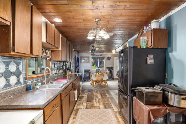 11681 Heron Dr, Lakeview, MI 48850 - kitchen featuring stainless steel fridge with ice dispenser, backsplash, light wood finished floors, a chandelier, and brown cabinetry