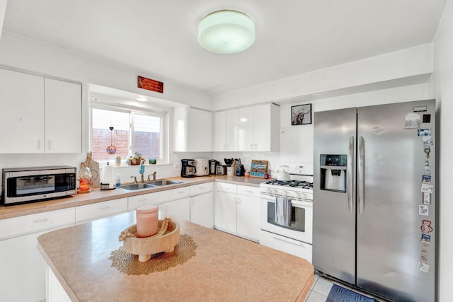 29206 Guy St, Southfield, MI 48076 - kitchen featuring appliances with stainless steel finishes, white cabinets, light countertops, and light tile patterned flooring