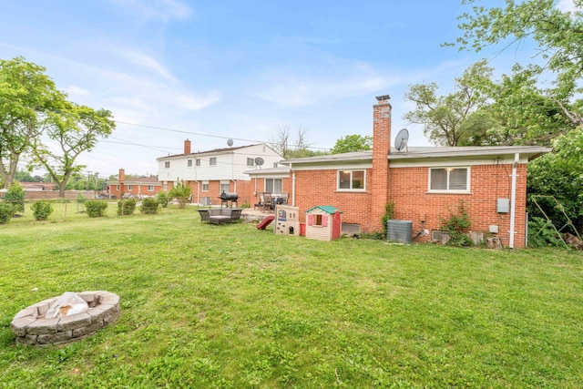 29206 Guy St, Southfield, MI 48076 - rear view of house with an outdoor fire pit, brick siding, and a chimney