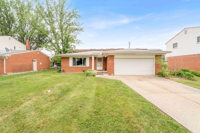 29206 Guy St, Southfield, MI 48076 - view of front facade with an attached garage, brick siding, driveway, and a front lawn