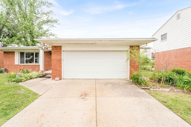 29206 Guy St, Southfield, MI 48076 - view of front of property featuring brick siding, concrete driveway, and a garage