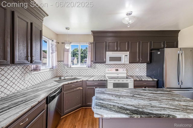 2274 Apple Tree Dr, Burton, MI 48519 - kitchen with stainless steel appliances, light wood-style flooring, light stone counters, and backsplash