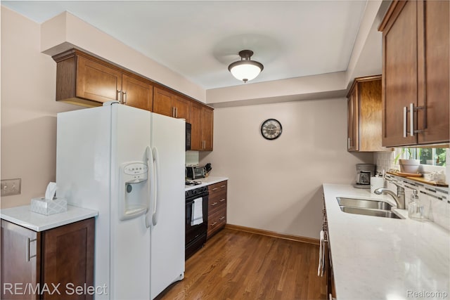 2249 Pauline Dr, Waterford, MI 48329 - kitchen featuring white refrigerator with ice dispenser, gas range oven, wood finished floors, and brown cabinetry