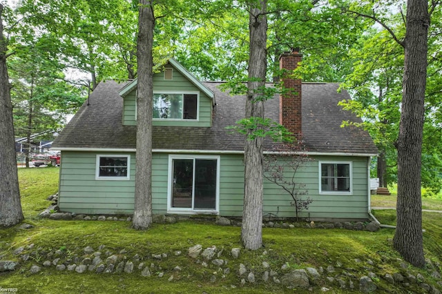 7199 Switzer Dr, Linden, MI 48451 - rear view of house featuring a chimney, a lawn, and roof with shingles