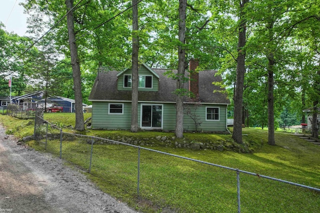 7199 Switzer Dr, Linden, MI 48451 - view of front of house with a shingled roof, a fenced backyard, and a chimney