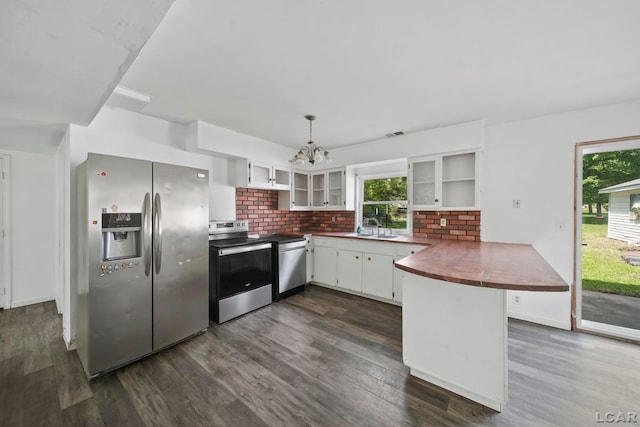 306 S Washington St, Manchester, MI 48158 - kitchen featuring stainless steel appliances, a peninsula, a chandelier, dark wood finished floors, and plenty of natural light