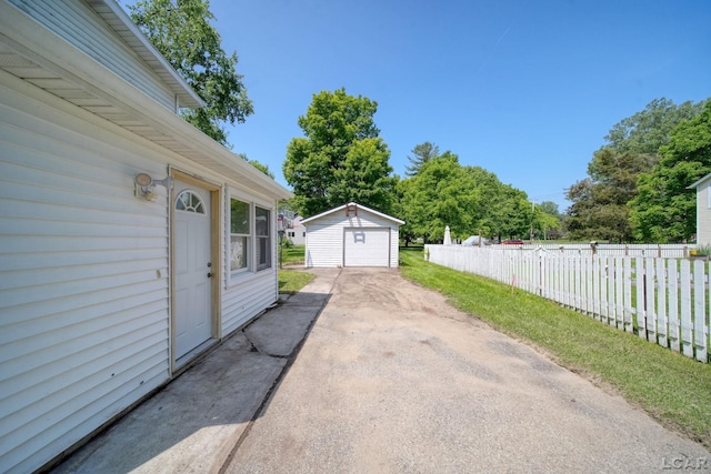 306 S Washington St, Manchester, MI 48158 - view of patio featuring driveway, a detached garage, and an outdoor structure