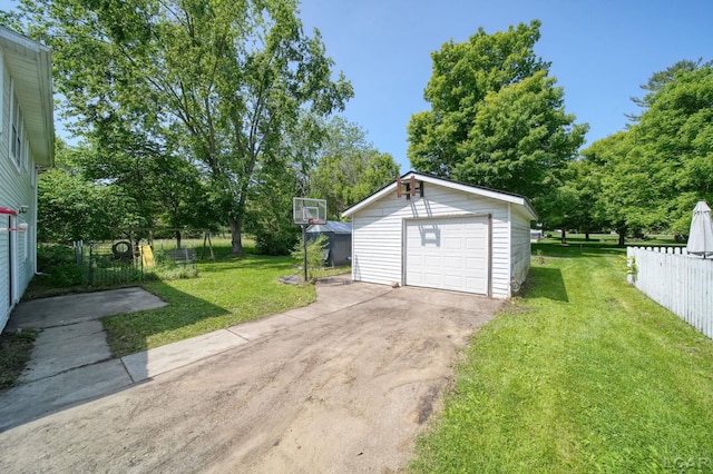 306 S Washington St, Manchester, MI 48158 - detached garage featuring driveway and view of scattered trees