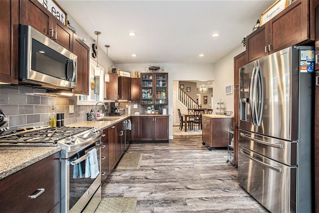 325 Marshall St, Coldwater, MI 49036 - kitchen with appliances with stainless steel finishes, recessed lighting, wood finished floors, light stone counters, and tasteful backsplash