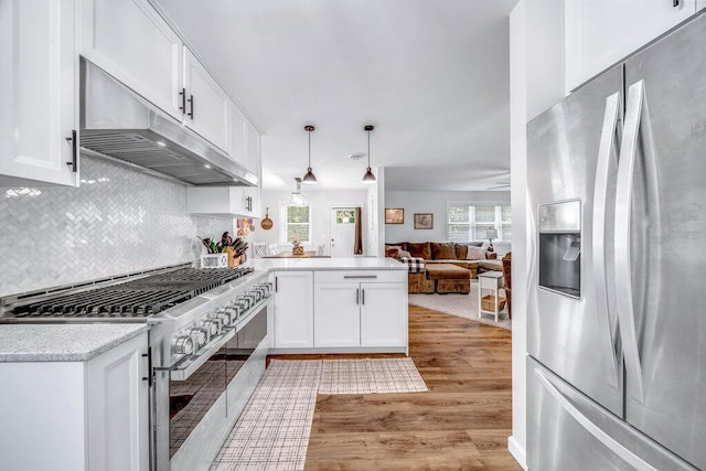 54727 Twin Lakes Rd, Dowagiac, MI 49047 - kitchen with appliances with stainless steel finishes, under cabinet range hood, a peninsula, light wood-style floors, and white cabinets