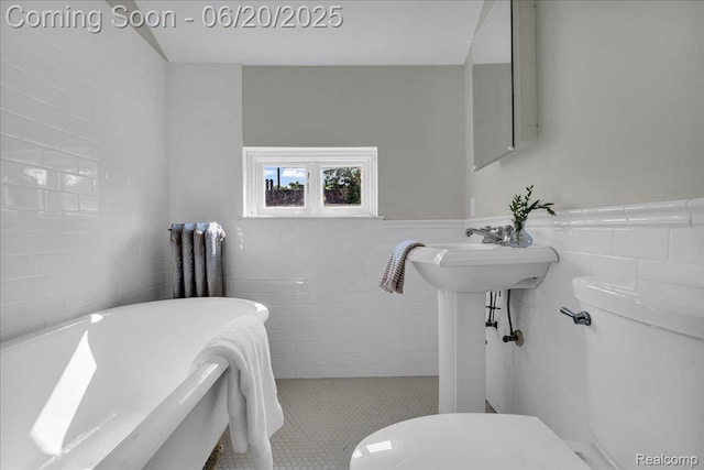 1710 Seminole St, Detroit, MI 48214 - bathroom featuring tile walls, a freestanding tub, tile patterned floors, and a wainscoted wall