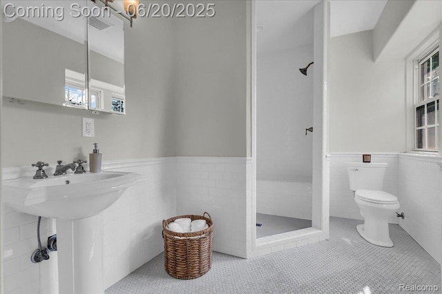 1710 Seminole St, Detroit, MI 48214 - bathroom featuring a shower stall, a wainscoted wall, tile walls, and tile patterned flooring