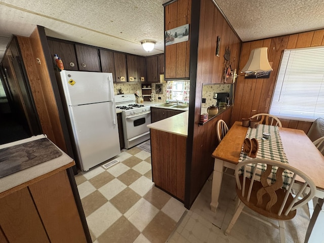5859 N Utter Rd, Irons, MI 49644 - kitchen featuring white appliances, light floors, a textured ceiling, a peninsula, and wooden walls