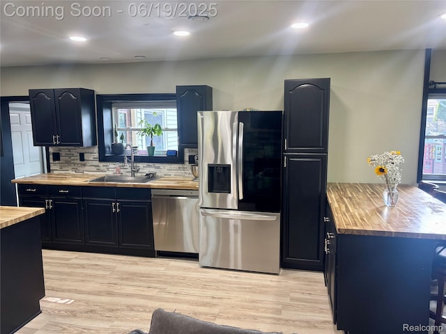 1745 Wisconsin Ave, Marysville, MI 48040 - kitchen with appliances with stainless steel finishes, butcher block counters, decorative backsplash, light wood-type flooring, and plenty of natural light