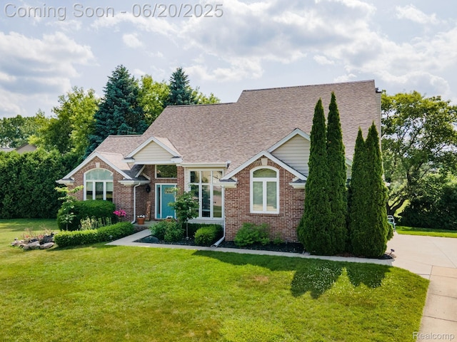 4096 Villager Dr, Lake Orion, MI 48359 - view of front of house featuring brick siding, a front yard, and roof with shingles