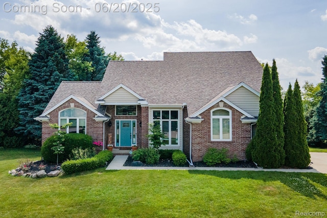 4096 Villager Dr, Lake Orion, MI 48359 - view of front of home featuring brick siding, a front yard, and a shingled roof