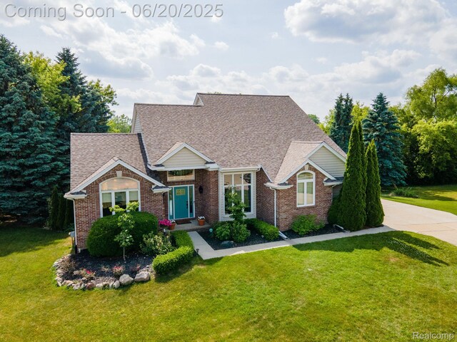 4096 Villager Dr, Lake Orion, MI 48359 - view of front of home featuring a front yard, brick siding, and roof with shingles