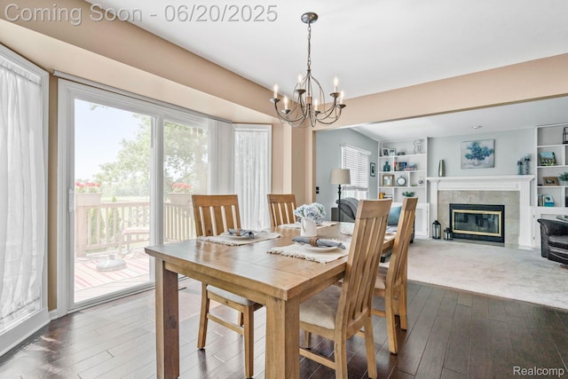 4096 Villager Dr, Lake Orion, MI 48359 - dining space with dark wood finished floors, a chandelier, and a fireplace