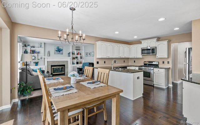4096 Villager Dr, Lake Orion, MI 48359 - dining area featuring a chandelier, dark wood-style floors, recessed lighting, and a glass covered fireplace
