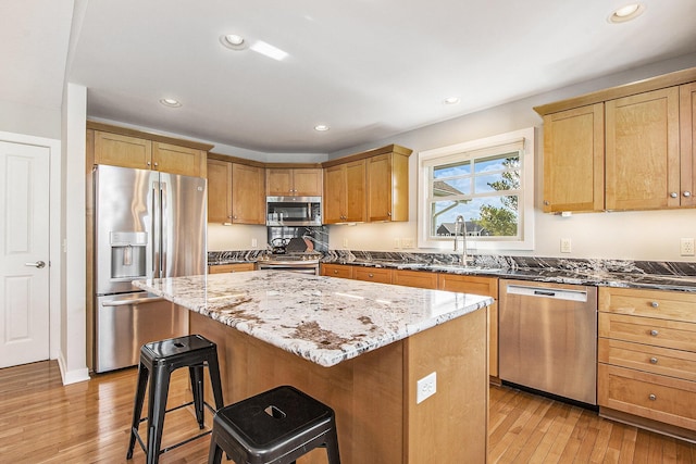 2069 Watermark Dr SE, Grand Rapids, MI 49546 - kitchen featuring stainless steel appliances, a kitchen bar, light wood finished floors, a kitchen island, and recessed lighting