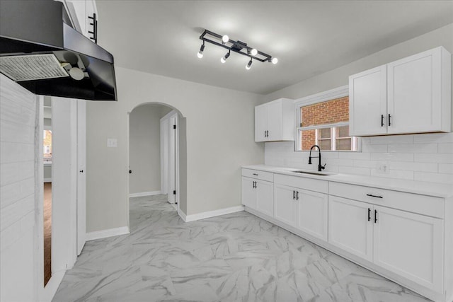 16241 Cherrylawn St, Detroit, MI 48221 - kitchen with arched walkways, light marble finish floors, tasteful backsplash, and light countertops