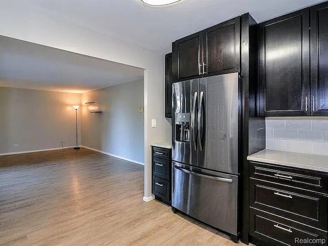 1050 Wall St Unit 2E, Ann Arbor, MI 48105 - kitchen with stainless steel refrigerator with ice dispenser, dark cabinets, light wood-style flooring, and light countertops