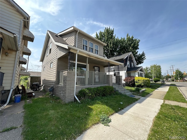 4222 High St, Ecorse, MI 48229 - view of front of house featuring a porch, a front yard, and stone siding