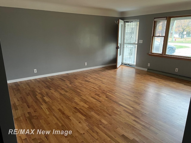 1910 Weiss St, Saginaw, MI 48602 - empty room featuring wood finished floors and baseboard heating