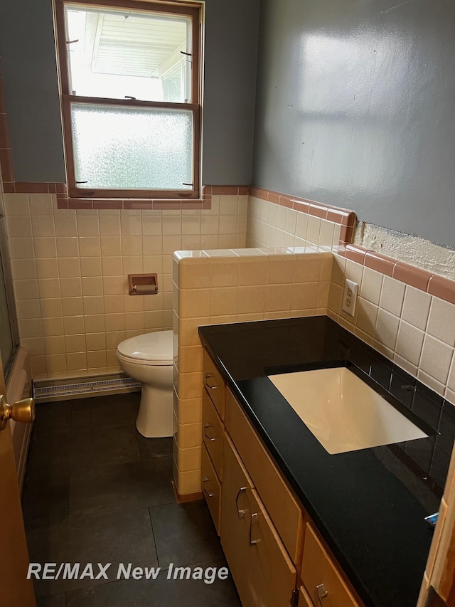 1910 Weiss St, Saginaw, MI 48602 - bathroom featuring vanity, tile patterned floors, tile walls, and wainscoting