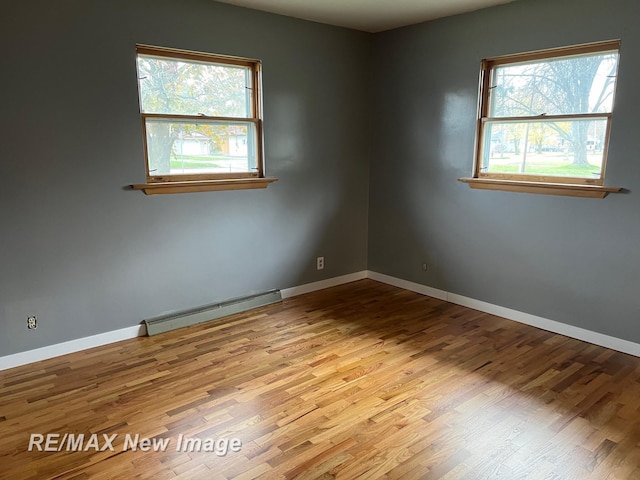 1910 Weiss St, Saginaw, MI 48602 - empty room featuring a baseboard radiator and wood finished floors