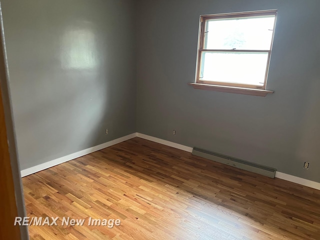 1910 Weiss St, Saginaw, MI 48602 - spare room featuring a baseboard heating unit and wood finished floors