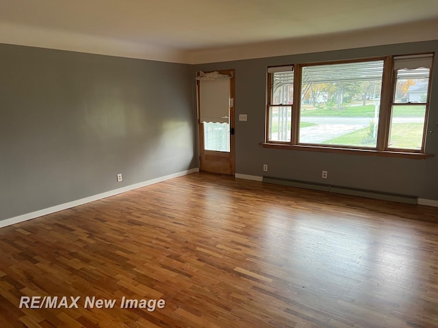 1910 Weiss St, Saginaw, MI 48602 - empty room with wood finished floors and baseboard heating