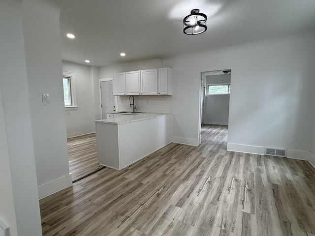 2427 Highland St, Detroit, MI 48206 - kitchen featuring light wood-style floors, white cabinets, light countertops, a peninsula, and recessed lighting